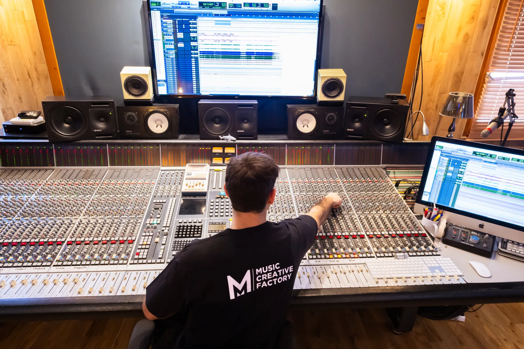 Ingénieur du son de dos aux commandes de la console analogique SSL