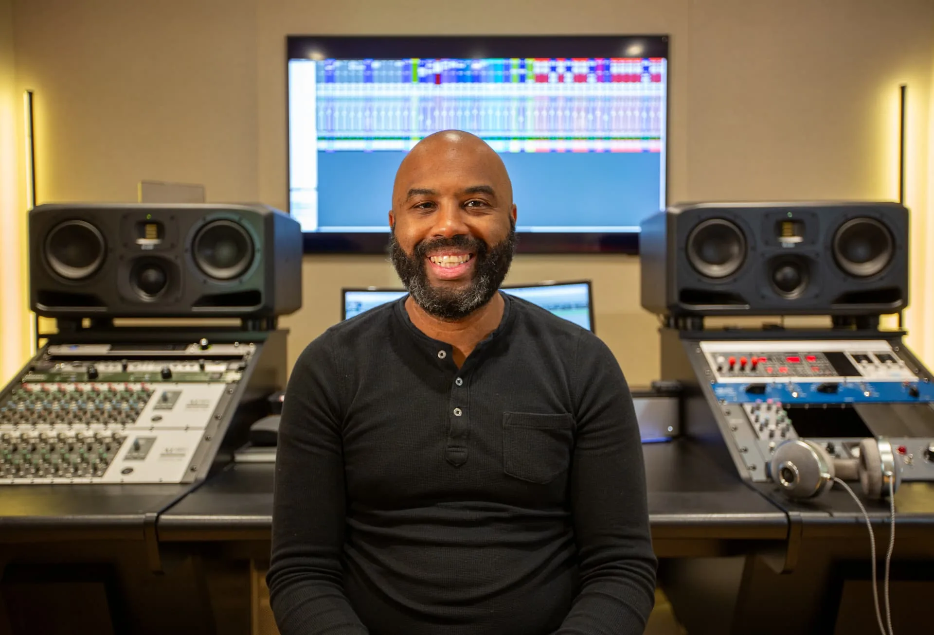 Fred N'Landu assis devant une console de mixage dans son studio