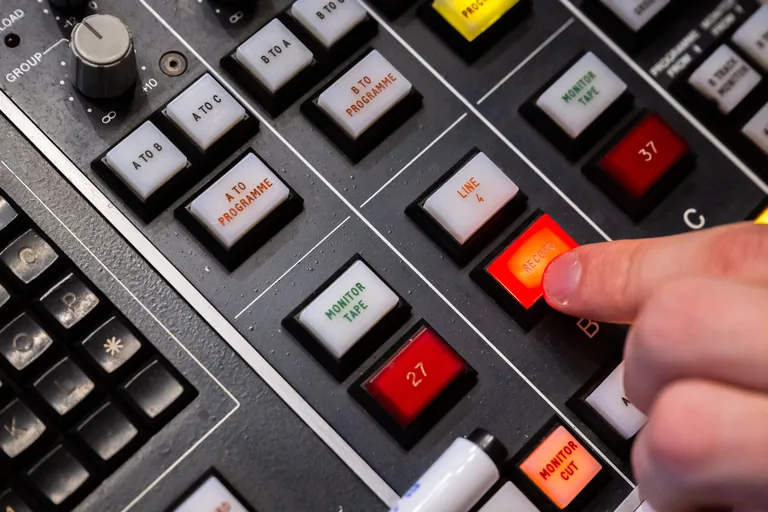 Doigt appuyant sur la touche Record d'une console de studio d'enregistrement